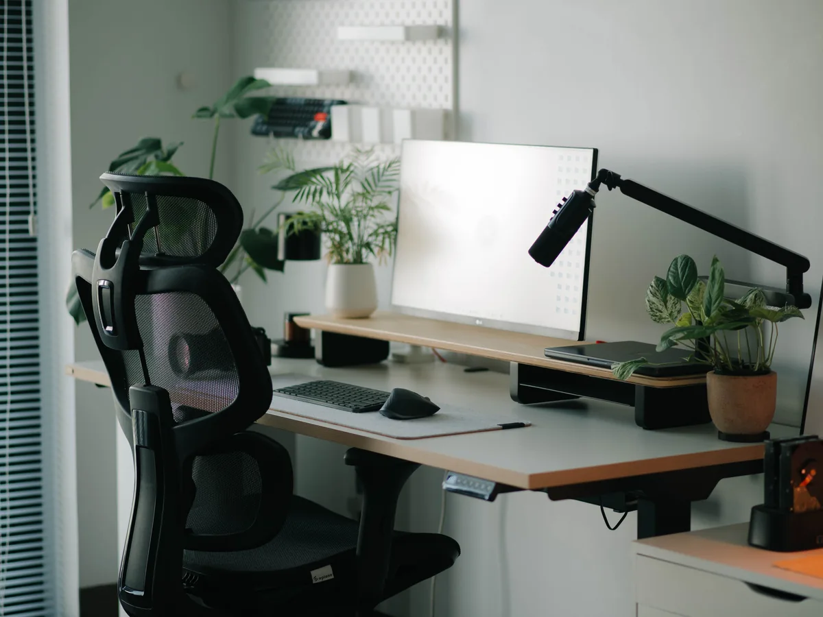 Real photo of an adjustable office desk with monitor and ergonomic chair
