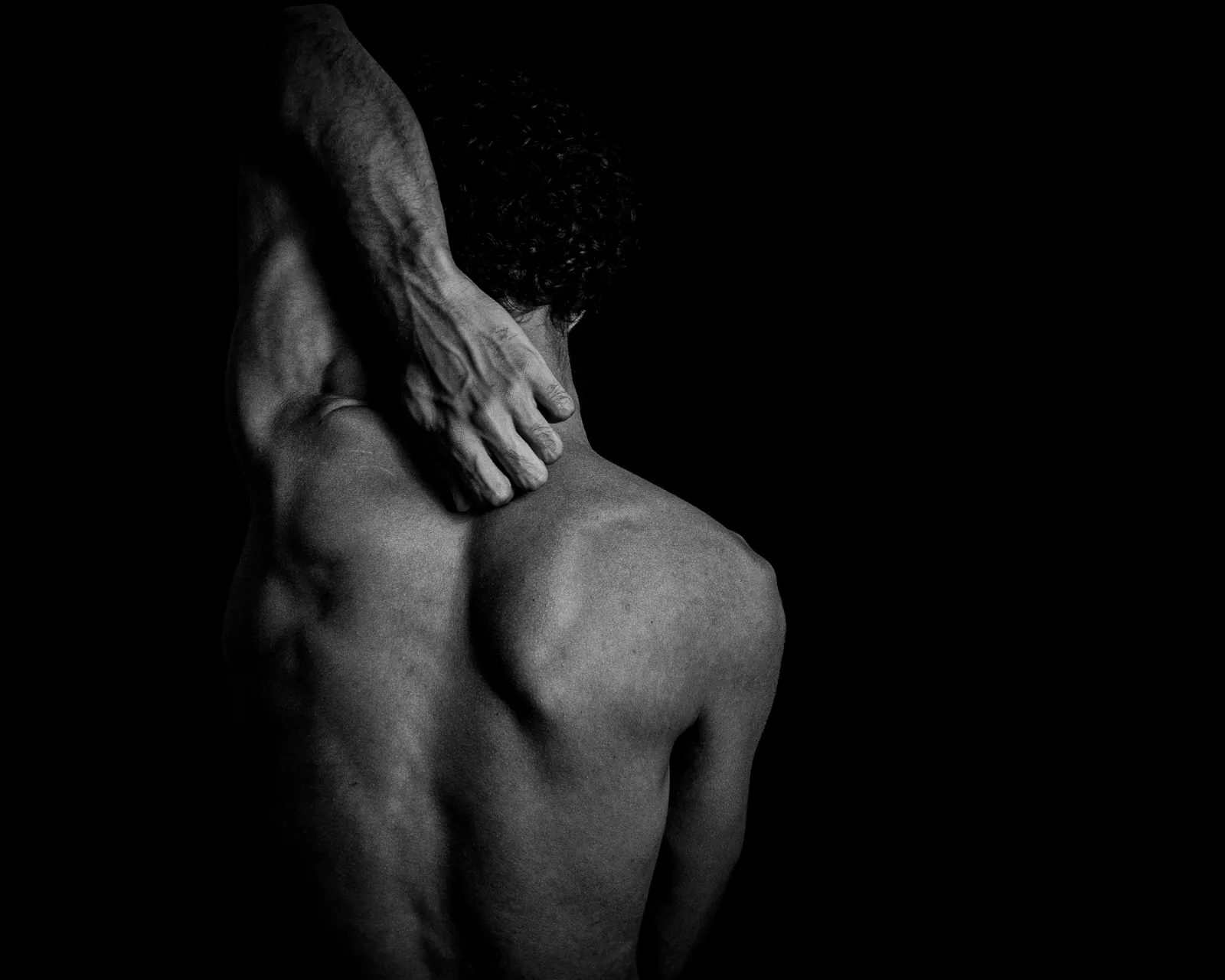 Athlete holding the upper back and shoulder after a sports injury