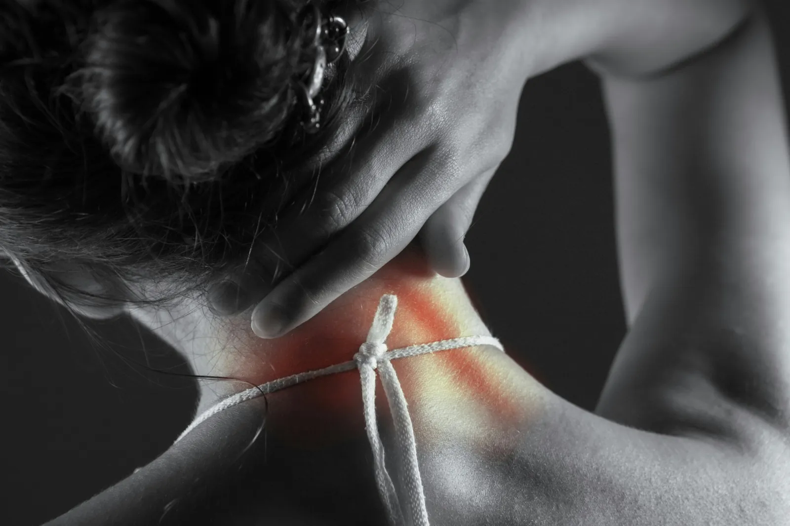 Person holding the back of the neck to illustrate whiplash pain after a car accident