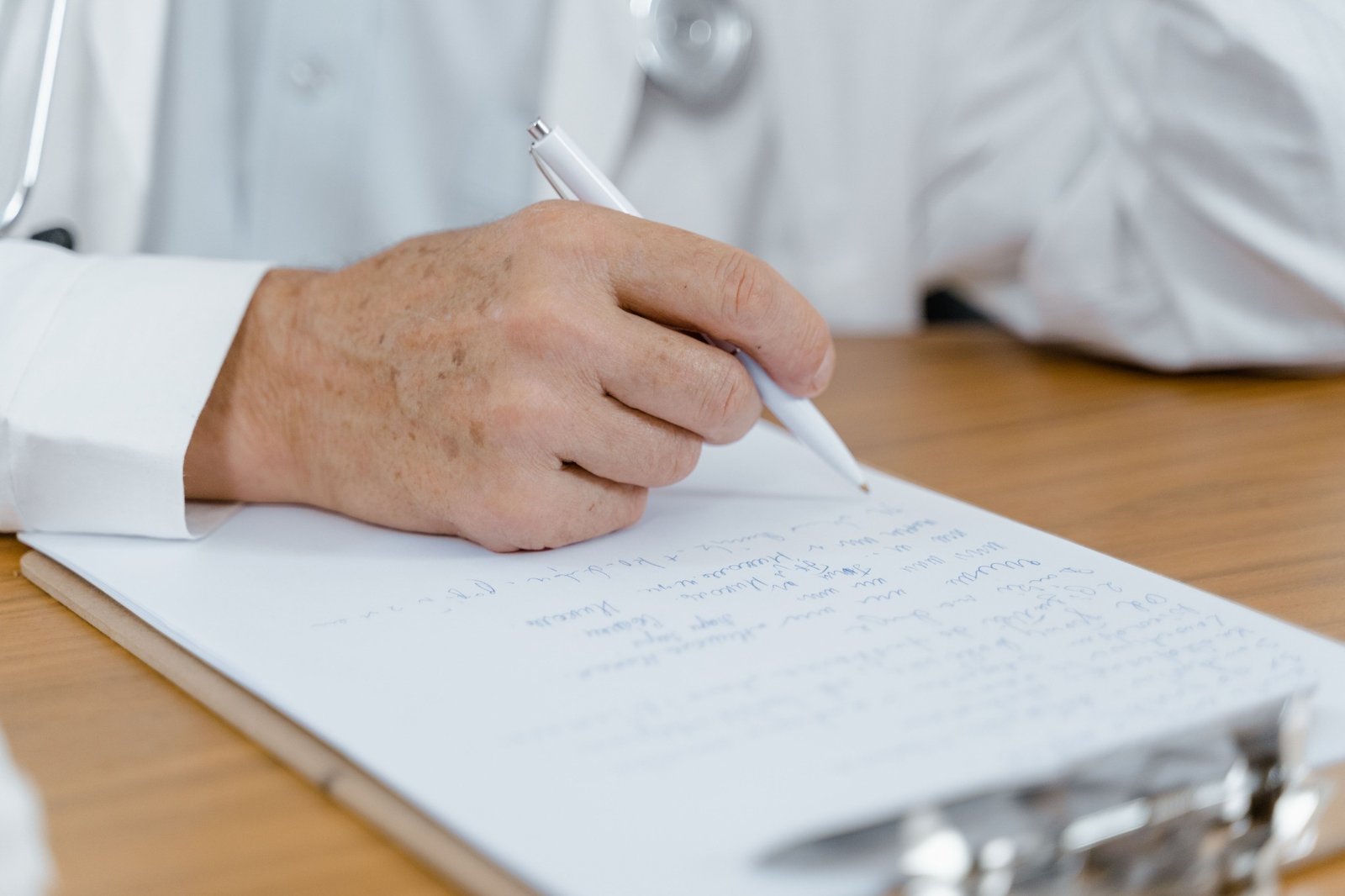 Clinician taking notes during a careful history and examination