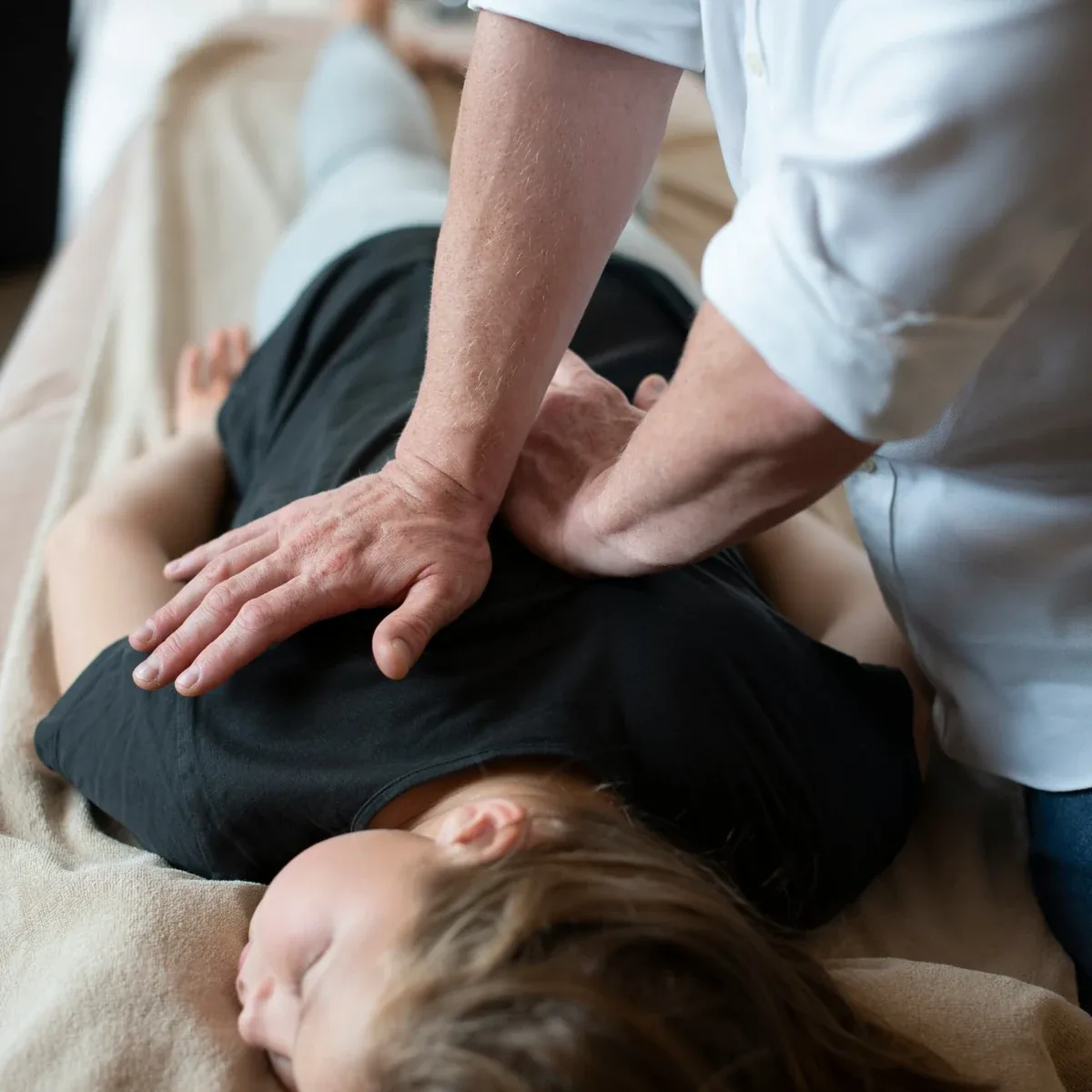 Chiropractic adjustment being performed on a patient’s upper back