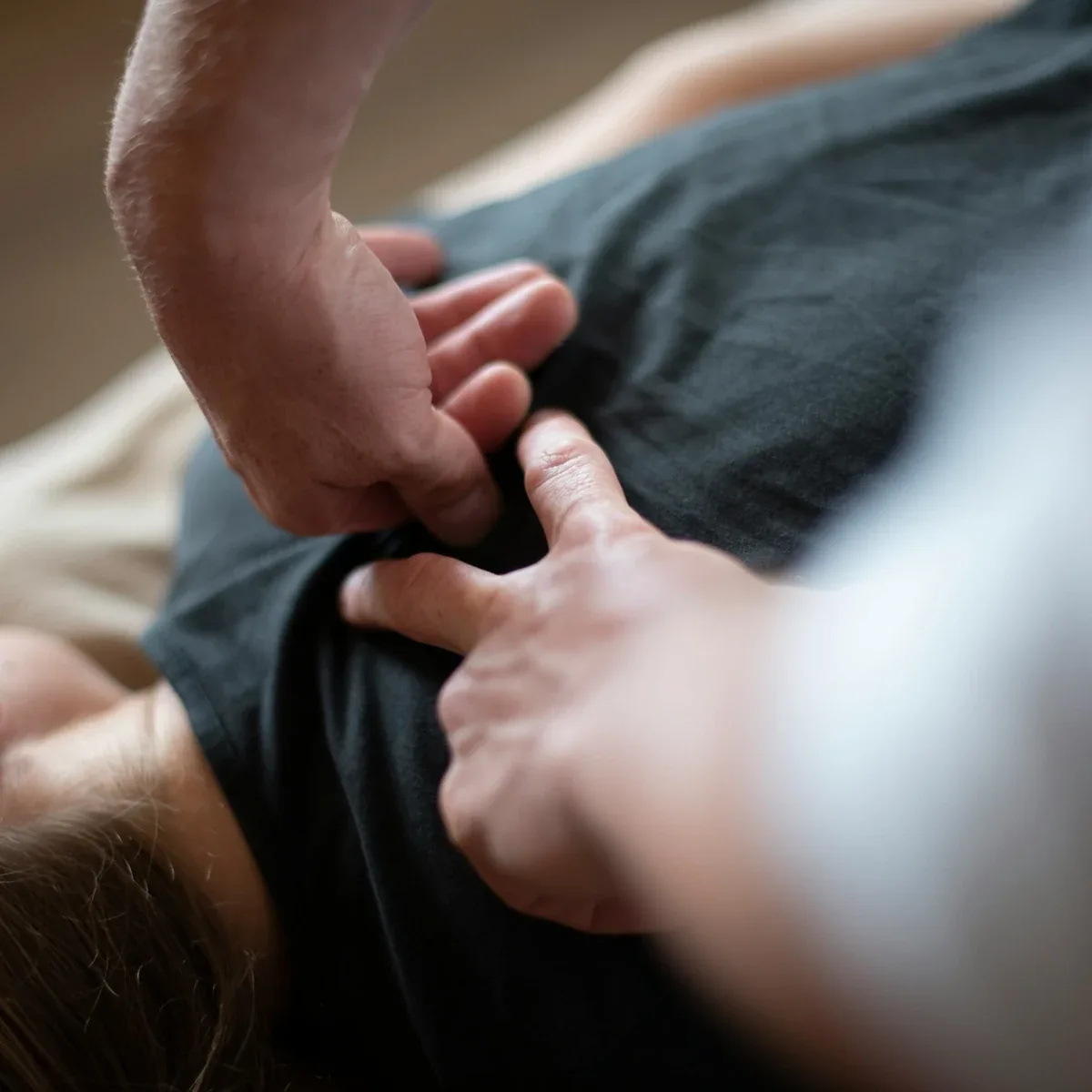 Hands applying focused soft-tissue therapy to the upper back